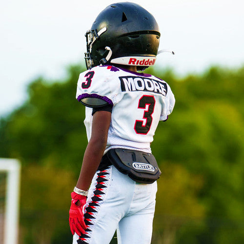 Youth football player wearing a classic black Battle back plate on the football field